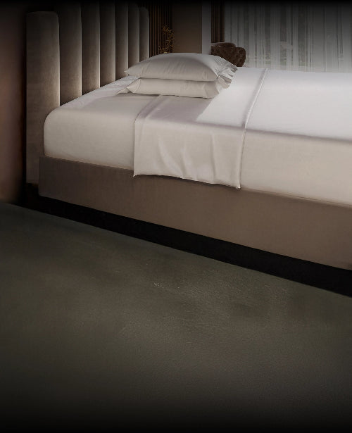 Neatly made Puffy Mattress with white bedding in a dimly lit room