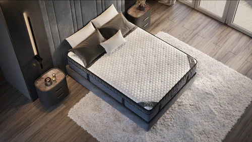 Mattress on display in a bedroom setting with pillows and a nightstand.