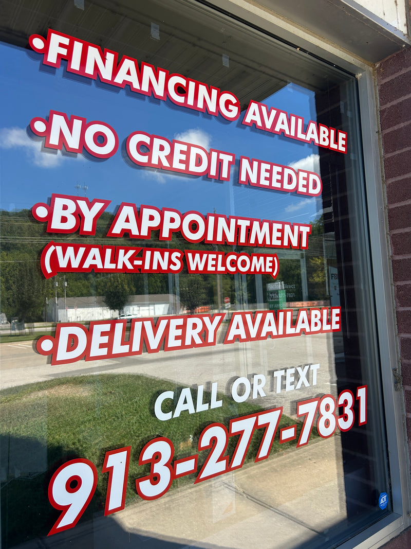 Promotional signs on a window with various offers and contact information.