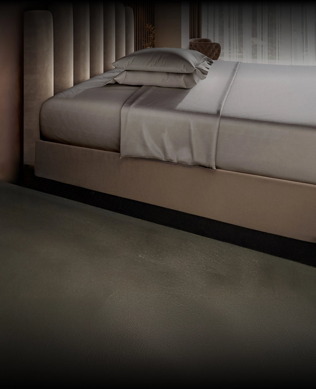Gray bed with gray Puffy bedding in a dimly lit room