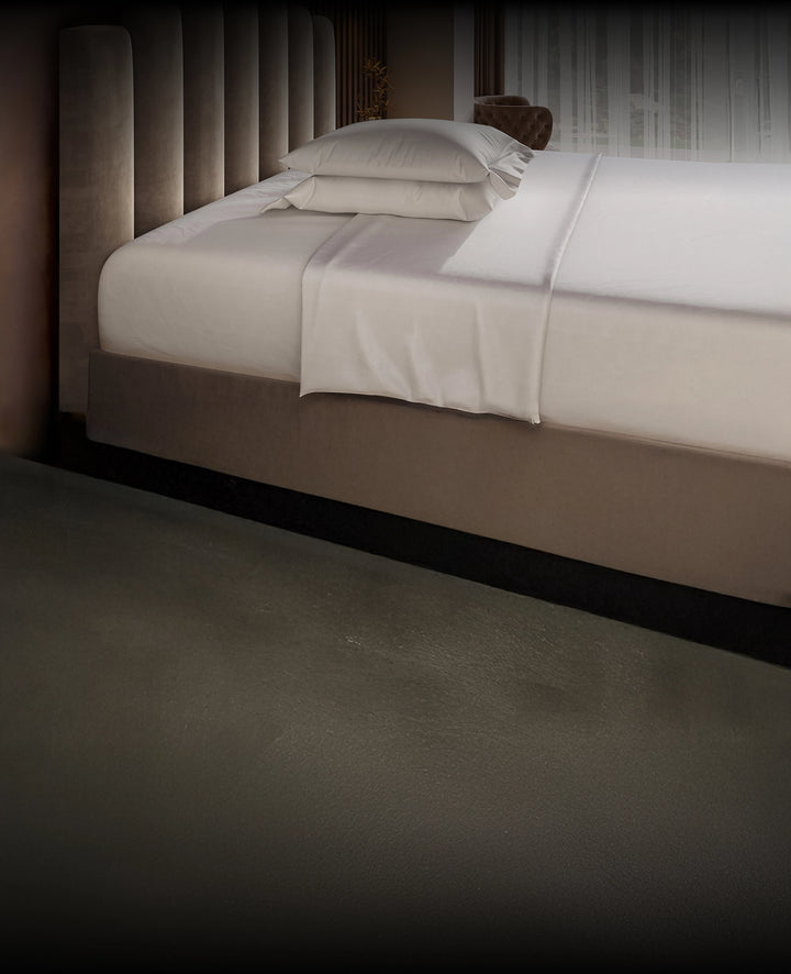 Neatly made Puffy Mattress with white bedding in a dimly lit room