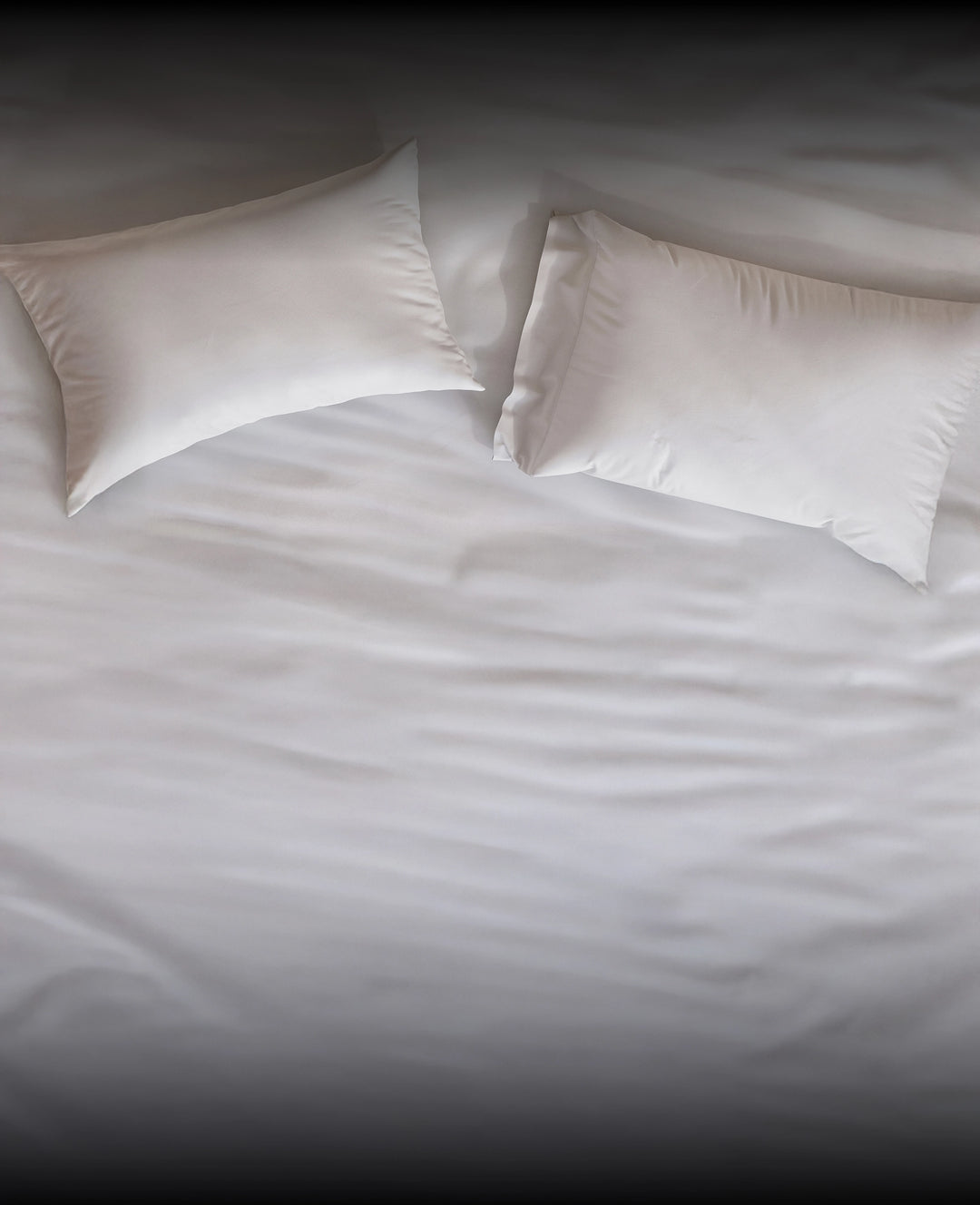 Two white pillows by Puffy on a bed with white bedding